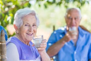 A happy senior man and woman sitting outside, enjoying the sun