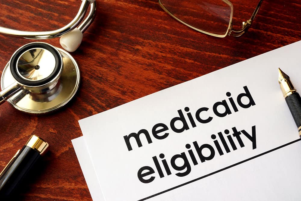 A document with the title Medicaid Eligibility on a table with medical equipment