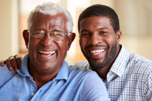 A senior father and his son smiling brightly